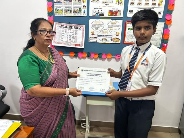 A teacher hands a certificate to a student in a classroom