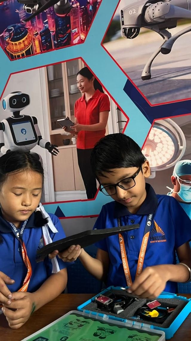 Two young students work together on an electronics kit in a robotics-themed classroom