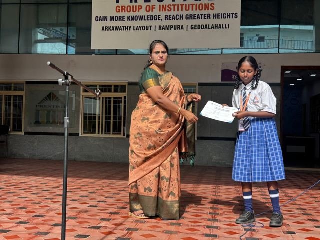A student receives a certificate from a teacher on stage