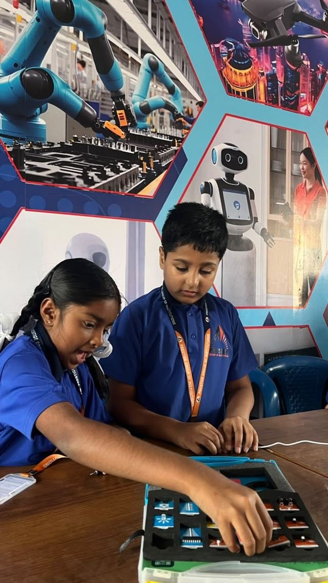 Two students explore modules in an electronics kit